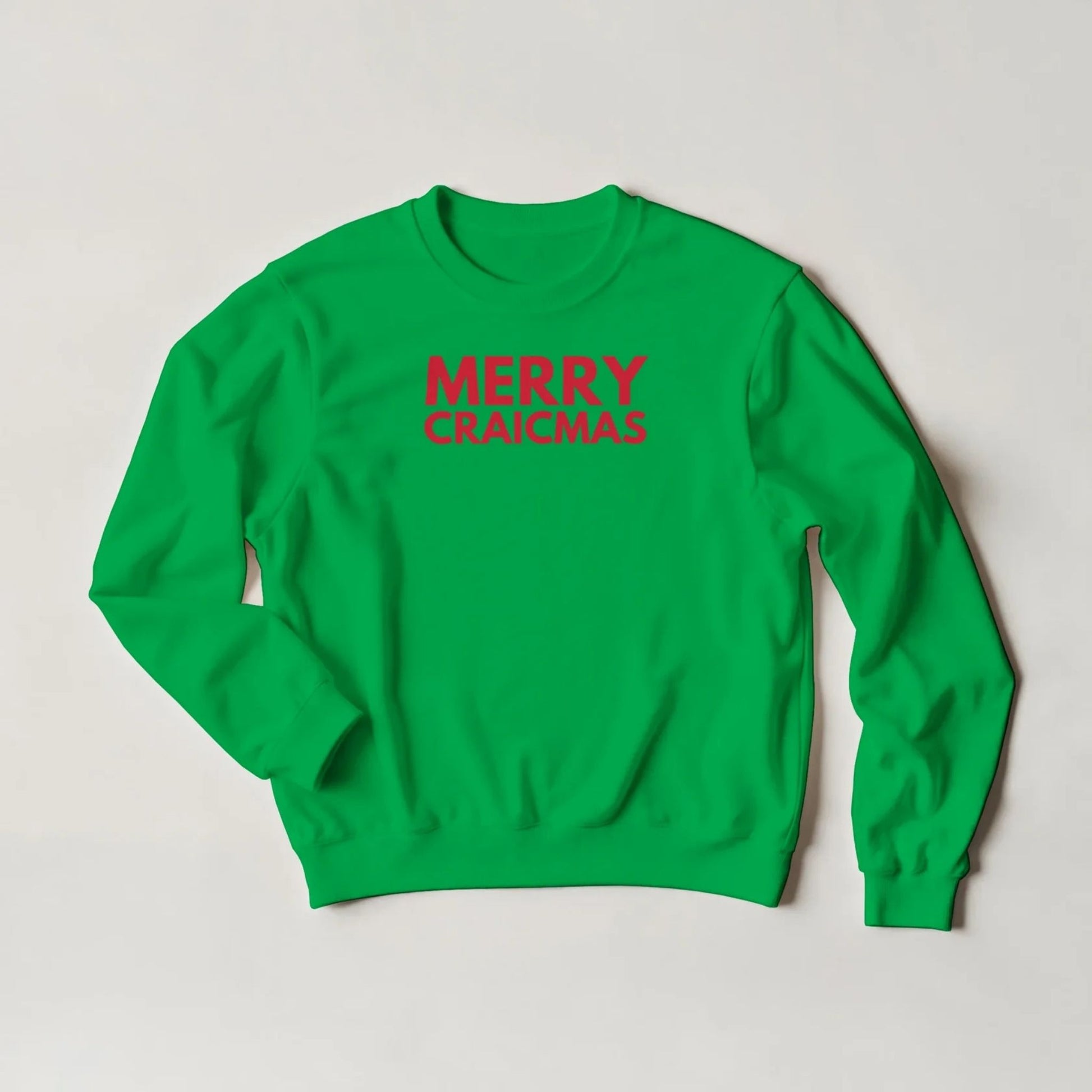 Green sweatshirt with 'MERRY CRAICMAS' redctext on a light grey background