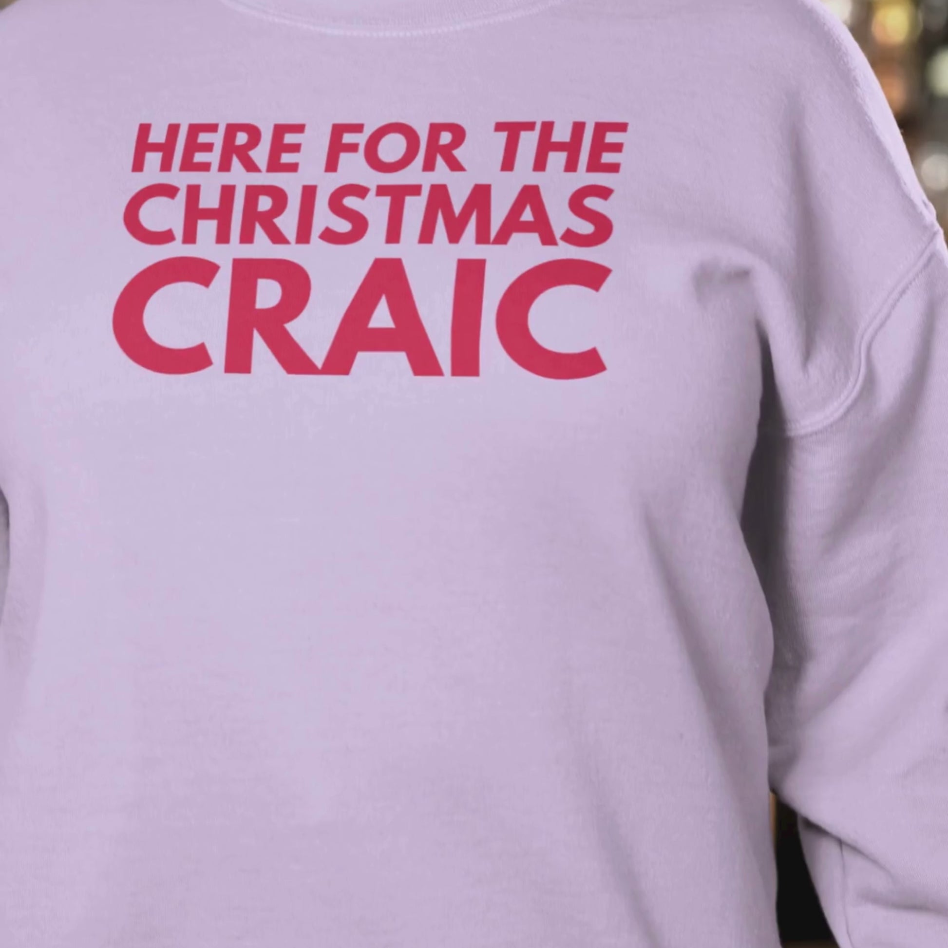 Pink sweatshirt with red text 'HERE FOR THE CHRISTMAS CRAIC' close up view
