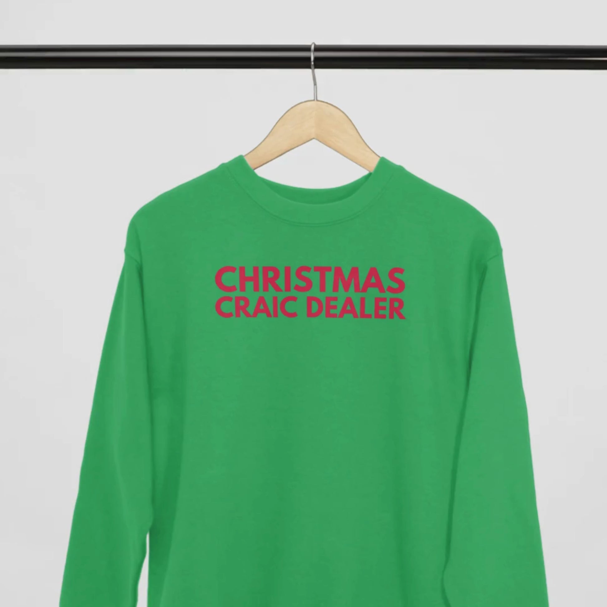 Green sweatshirt with red text 'CHRISTMAS CRAIC DEALER' on hanger with a white background