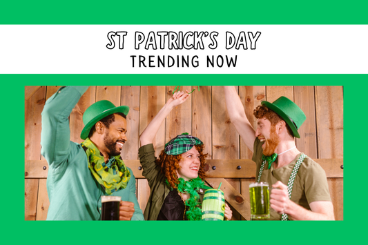 Three people holding green pints and celebrating St Patrick's Day with shamrock accessories and hats