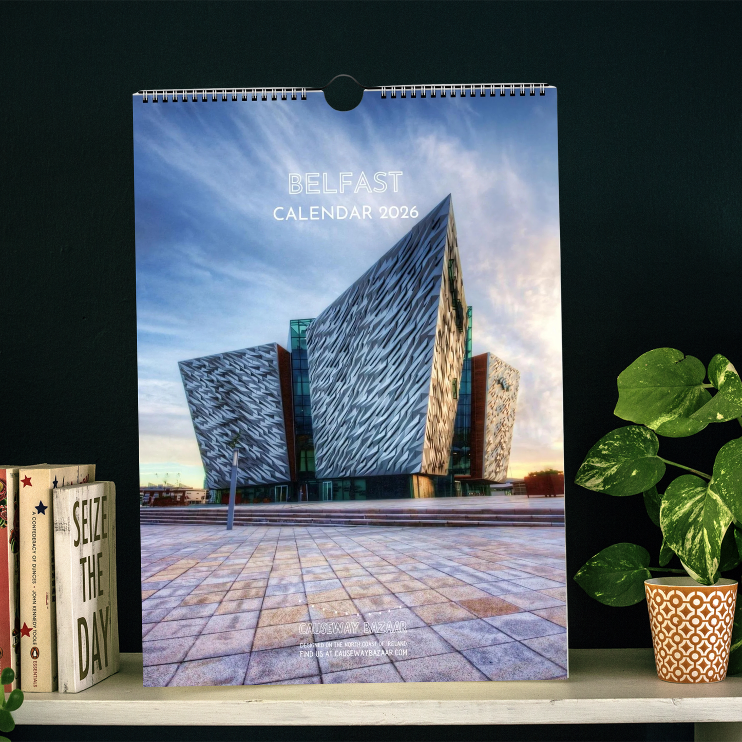 Belfast Calendar 2026 titled 'Belfast' featuring Titanic Museum building on the front cover placed on a shelf.