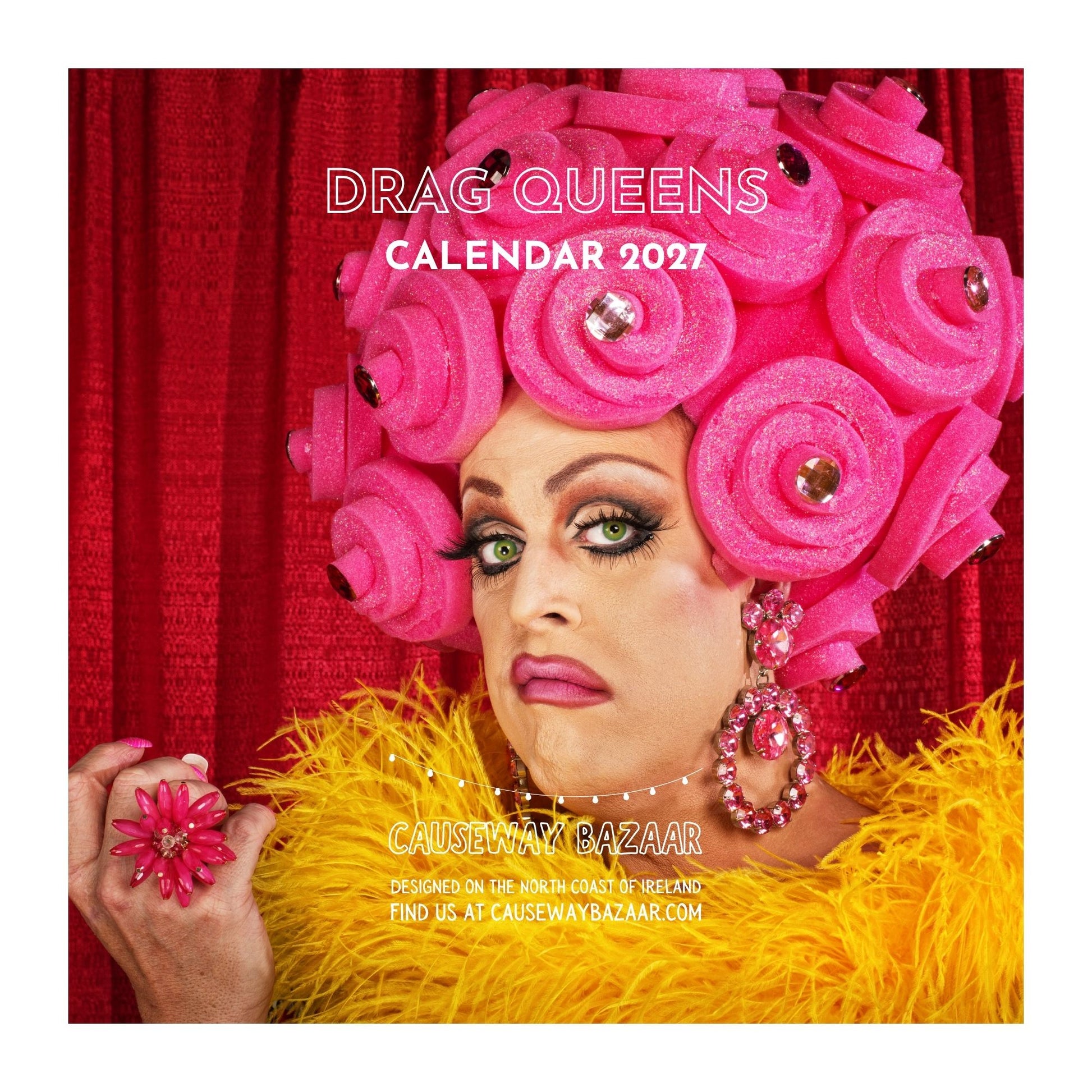 A square promotional image for the 'Drag Queens Calendar 2027' by Causeway Bazaar, featuring a close-up portrait of a drag queen with a large pink hairpiece, red curtain background, and yellow feather boa. The text 'DRAG QUEENS CALENDAR 2027' and 'CAUSEWAY BAZAAR' are visible.