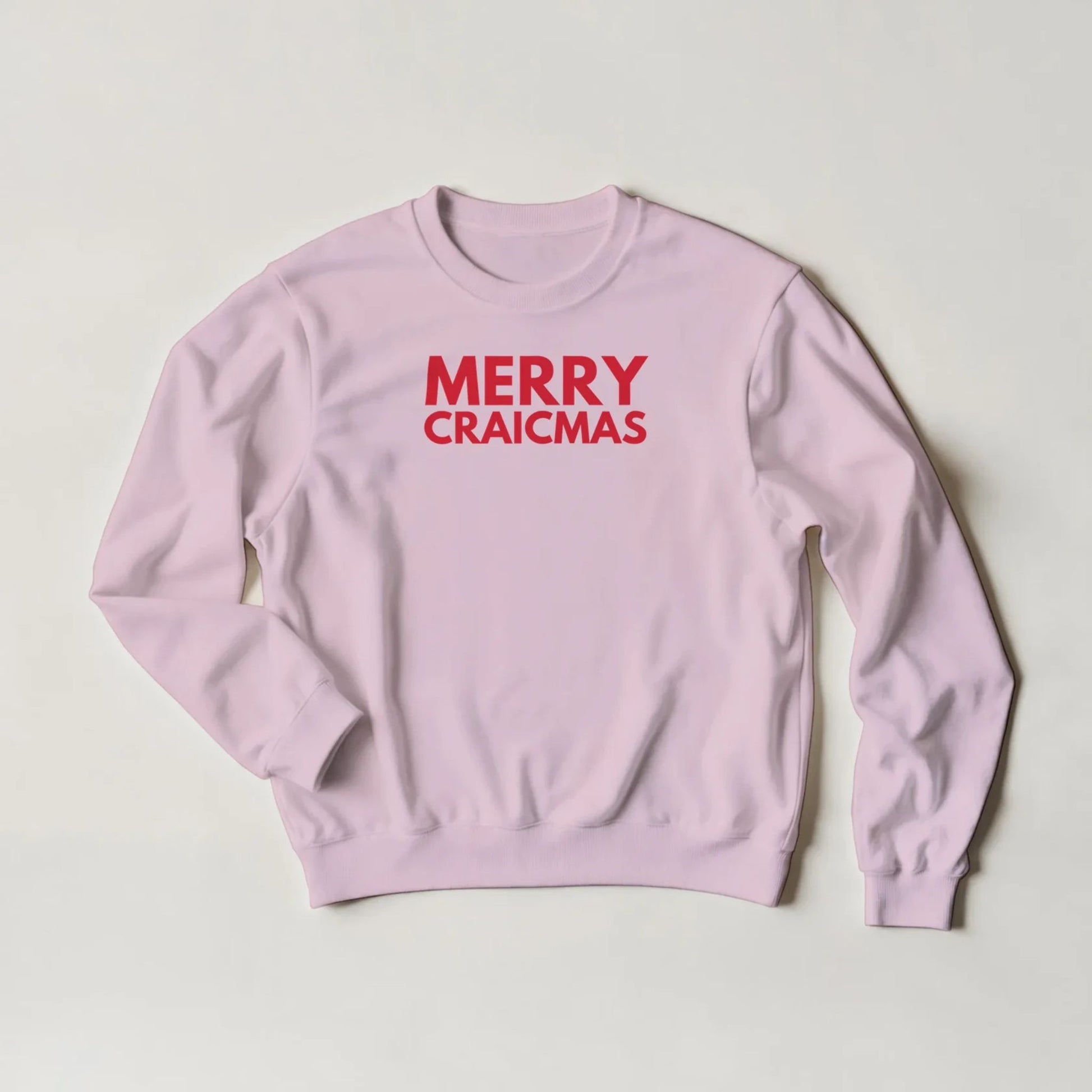 Pink sweatshirt with 'MERRY CRAICMAS' red text on a light grey background