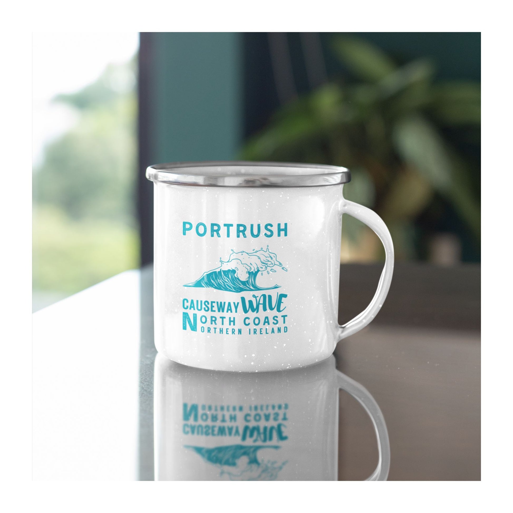 White mug with Portrush Causeway Wave North Coast Northern Ireland text and wave graphic on a white background on a table