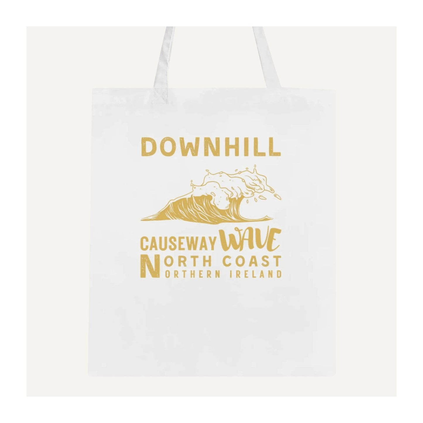 White tote bag with gold text 'Downhill Causeway Wave North Coast Northern Ireland' and wave design on a white background