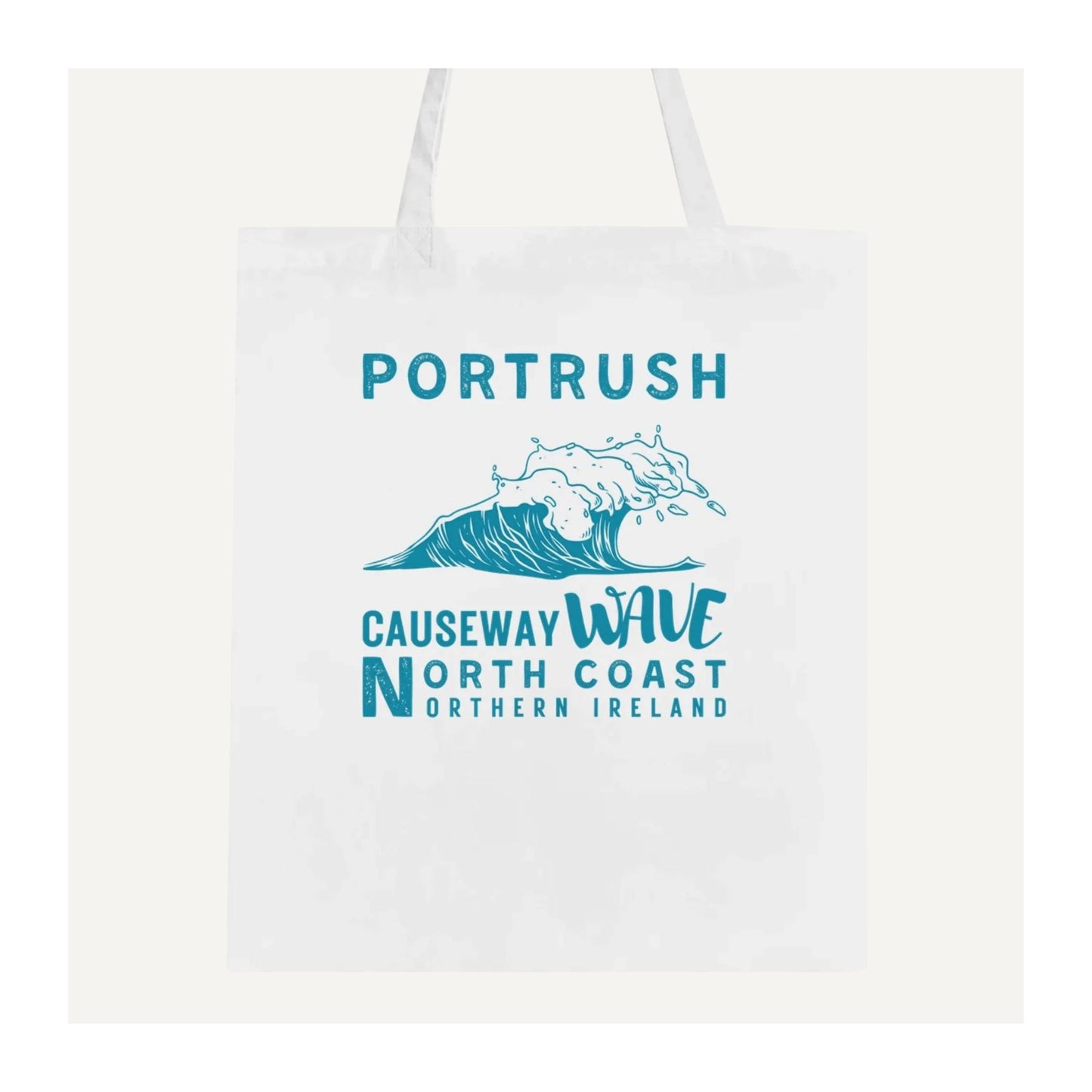 White tote bag with blue text 'Portrush Causeway Wave North Coast Northern Ireland' and wave graphic on a white background