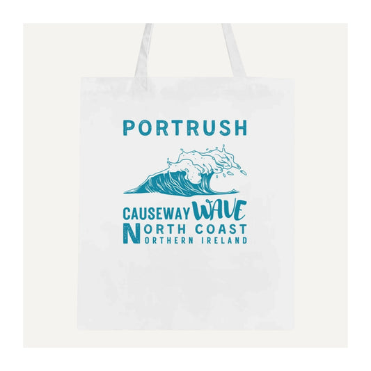 White tote bag with blue text 'Portrush Causeway Wave North Coast Northern Ireland' and wave graphic on a white background