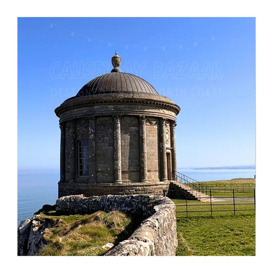 Mussenden Temple round stone building perched on a clifftop at Benone on the North Coast with clear blue sky. Image depicts Art print available for sale.