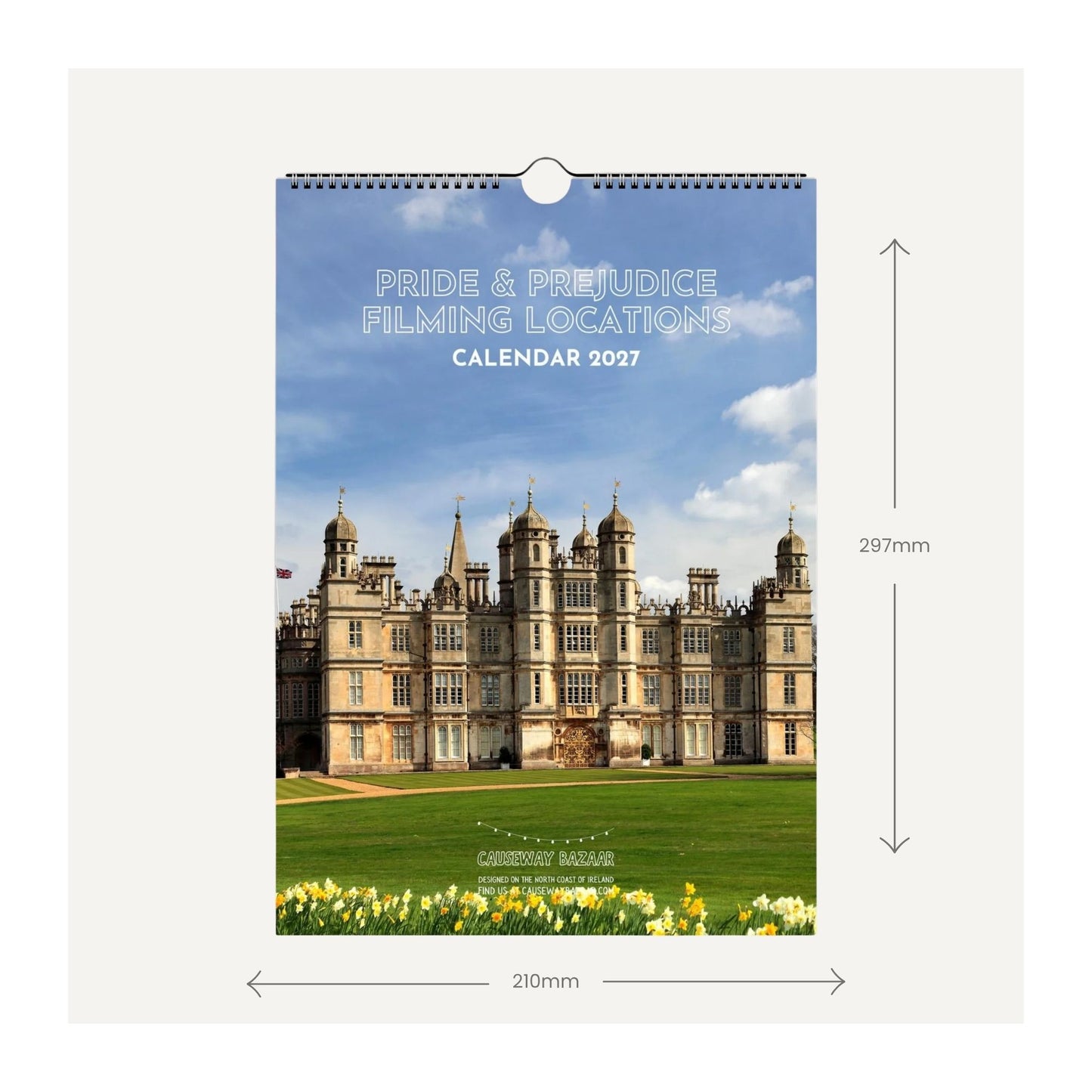 A wall calendar cover shown front-facing with dimension arrows and labels indicating 210 mm wide by 297 mm tall. The cover features a large stone manor house on green lawns under a blue sky, with the text 'PRIDE & PREJUDICE FILMING LOCATIONS CALENDAR 2027' 