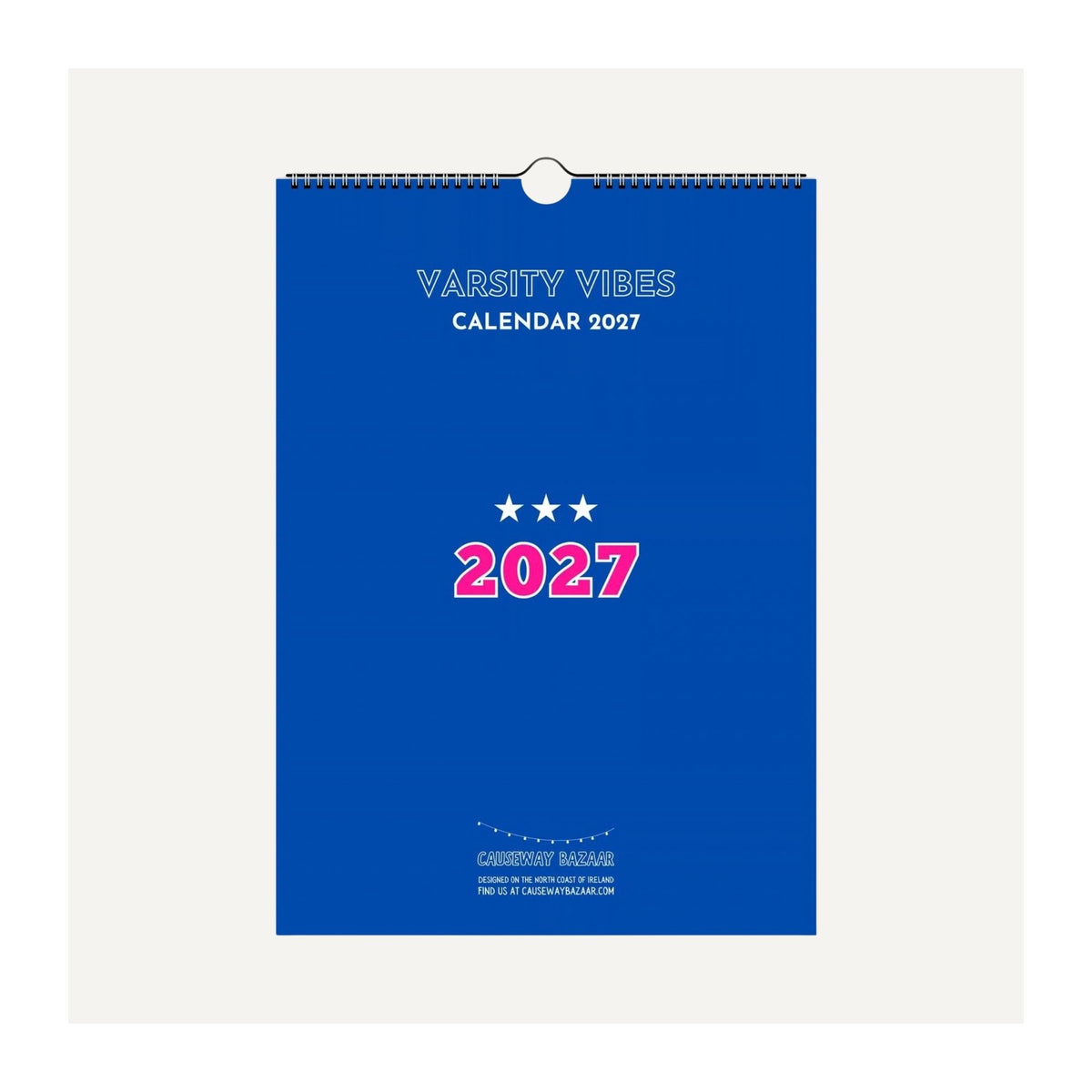 Varsity Vibes 2027 wall calendar mock-up featuring a blue cover with pink 2027 lettering, white stars and varsity-inspired design.